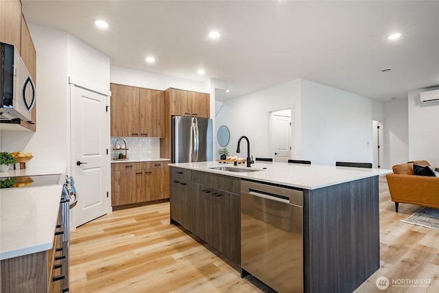710 E 5th St, Nooksack, WA 98276 - kitchen with decorative backsplash, modern cabinets, a sink, light wood finished floors, and appliances with stainless steel finishes