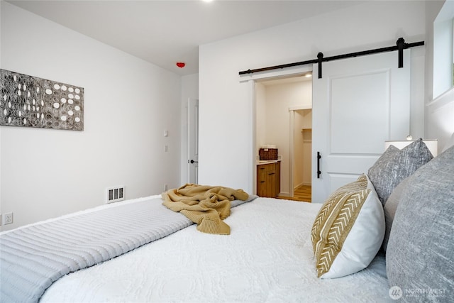 710 E 5th St, Nooksack, WA 98276 - bedroom featuring visible vents, a barn door, and ensuite bathroom