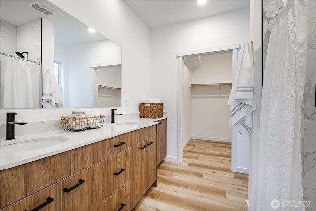 710 E 5th St, Nooksack, WA 98276 - full bathroom with visible vents, a sink, wood finished floors, and double vanity