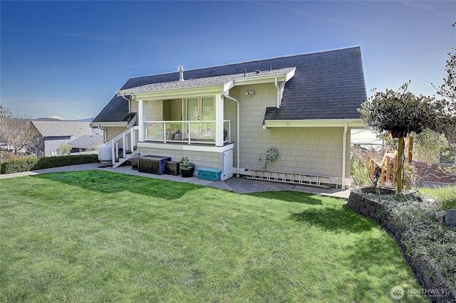 view of front facade featuring a front lawn and roof with shingles