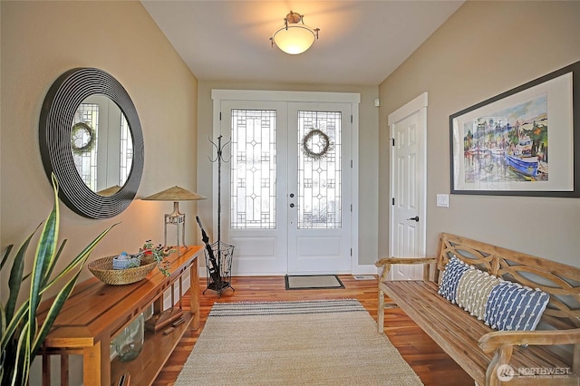 foyer entrance with wood finished floors and baseboards
