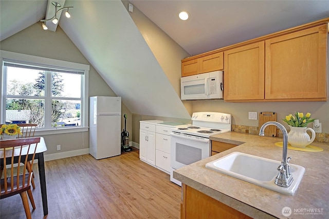 kitchen with vaulted ceiling, light wood finished floors, a sink, and white appliances