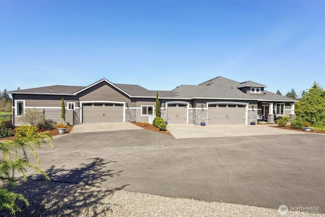 view of front of home featuring concrete driveway, stone siding, and a garage
