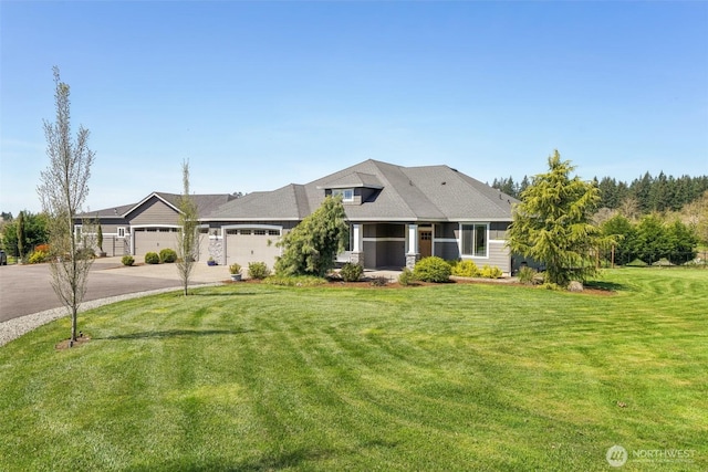 view of front of home featuring a garage, a front lawn, and concrete driveway