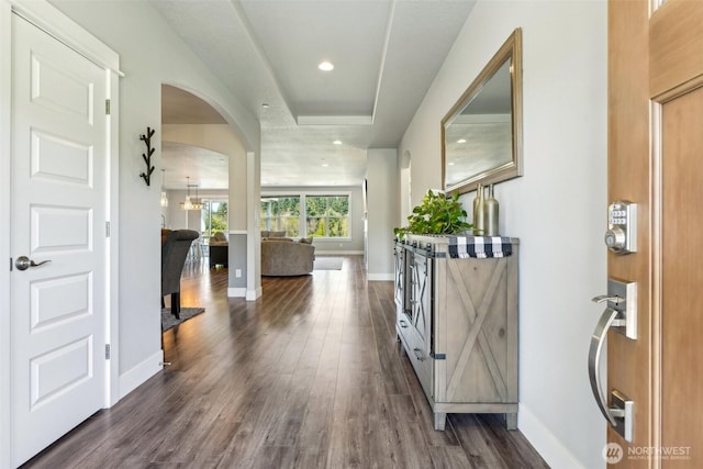 interior space featuring arched walkways, baseboards, dark wood-style flooring, and recessed lighting