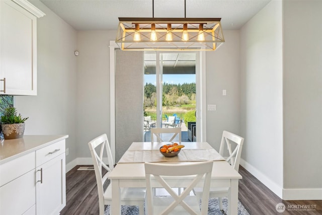 dining room with baseboards and dark wood-style flooring