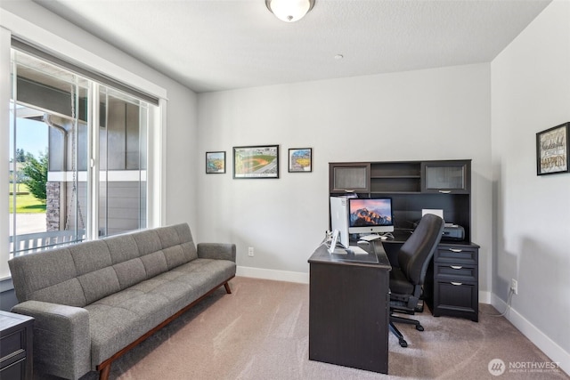 office space featuring light carpet and baseboards