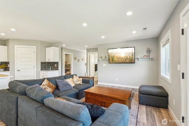 living area featuring light wood-type flooring, baseboards, recessed lighting, and visible vents