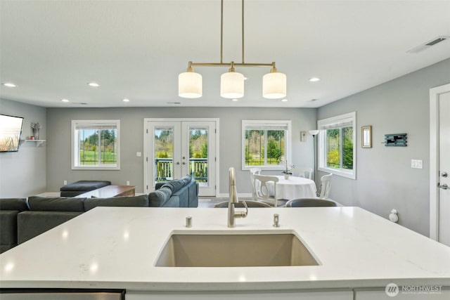 kitchen featuring recessed lighting, visible vents, a sink, a kitchen island with sink, and open floor plan
