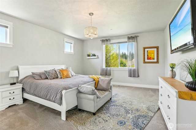 carpeted bedroom featuring baseboards and a textured ceiling