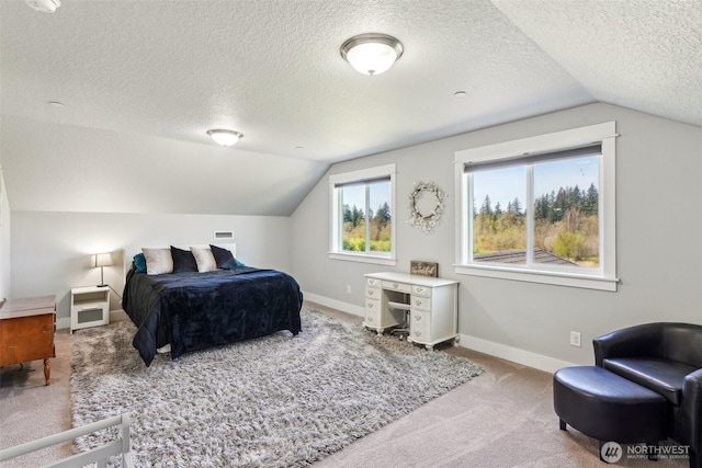 carpeted bedroom with vaulted ceiling, a textured ceiling, and baseboards