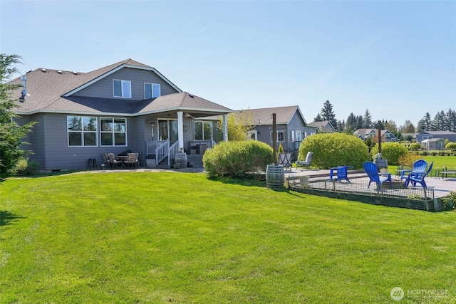 rear view of house with an outdoor fire pit, a yard, a patio, and a shingled roof