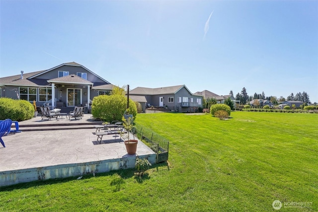rear view of property featuring a lawn and a patio