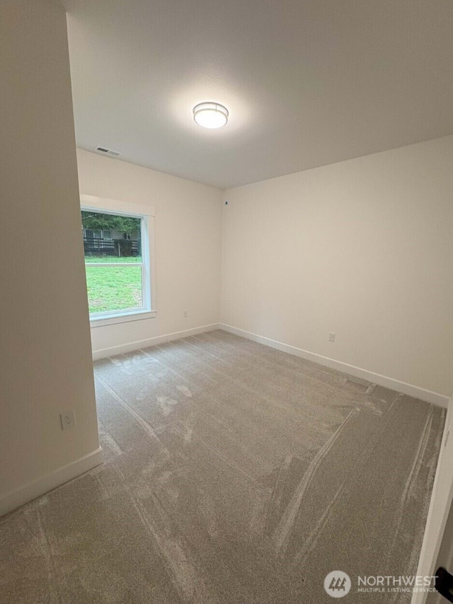 carpeted empty room featuring visible vents and baseboards