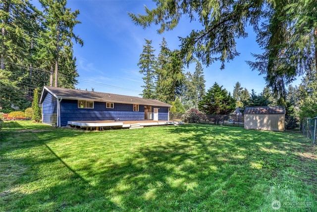 view of yard with a storage shed, a fenced backyard, a wooden deck, and an outdoor structure