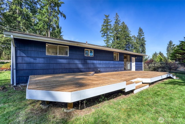 rear view of house featuring a yard, fence, and a deck