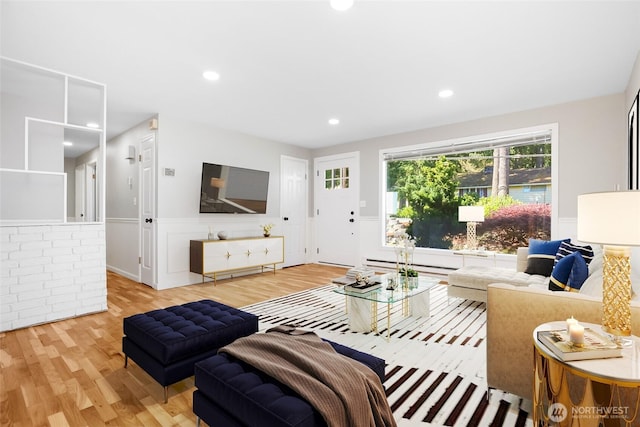 living room featuring a baseboard radiator, light wood-type flooring, wainscoting, and recessed lighting