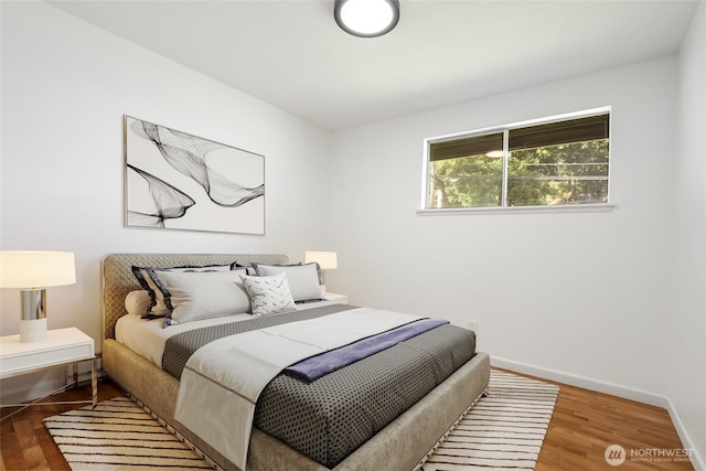 bedroom featuring baseboards and wood finished floors