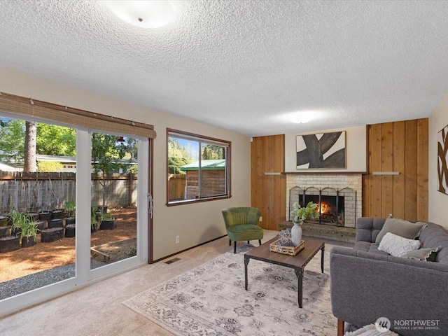 8142 NE 145th Pl, Kenmore, WA 98028 - living area featuring a textured ceiling, wood walls, visible vents, light carpet, and a brick fireplace