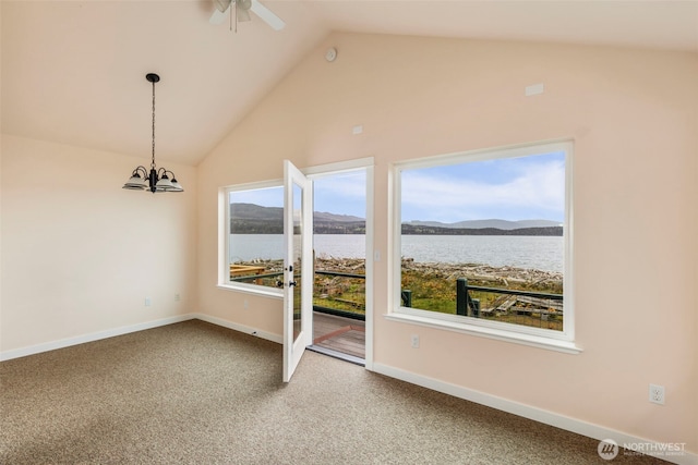 840 Beckett Point Rd, Port Townsend, WA 98368 - carpeted spare room featuring baseboards, vaulted ceiling, ceiling fan with notable chandelier, and a water and mountain view