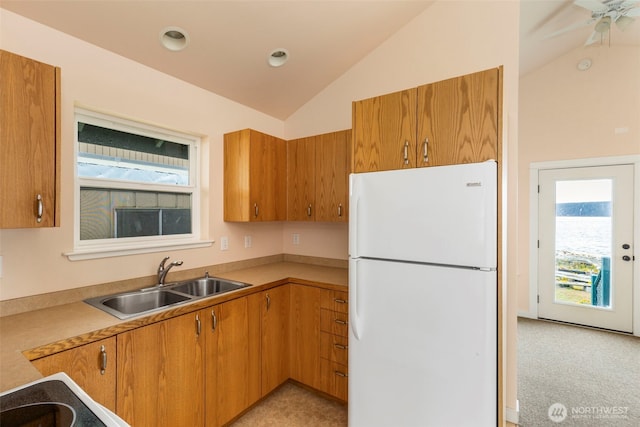 840 Beckett Point Rd, Port Townsend, WA 98368 - kitchen featuring brown cabinetry, a sink, freestanding refrigerator, and lofted ceiling