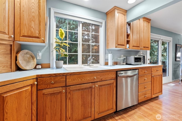 2336 Killarney Ct NW, Olympia, WA 98502 - kitchen with stainless steel dishwasher, light countertops, light wood finished floors, a sink, and brown cabinets