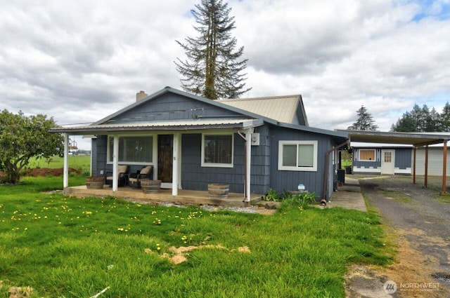 bungalow-style home with a carport, a front yard, and a porch