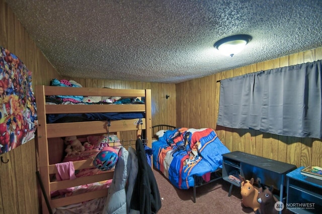 carpeted bedroom featuring a textured ceiling and wooden walls