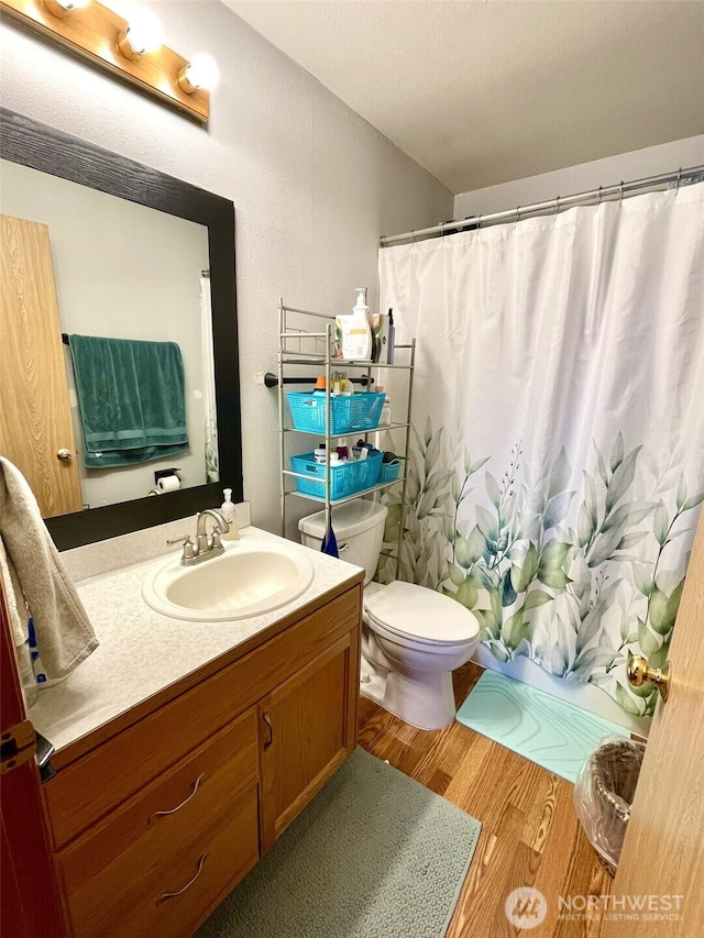 full bath featuring toilet, vanity, a shower with curtain, and wood finished floors