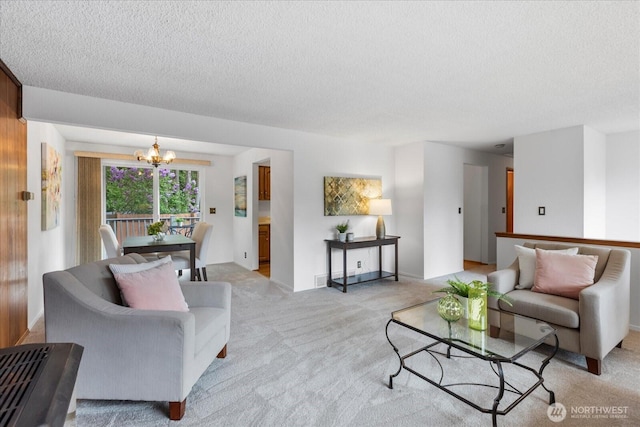 living room with a textured ceiling, a chandelier, and light carpet