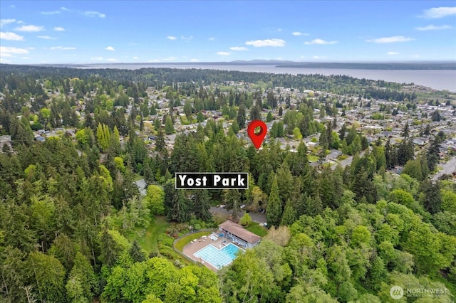 aerial view with a water view and a wooded view