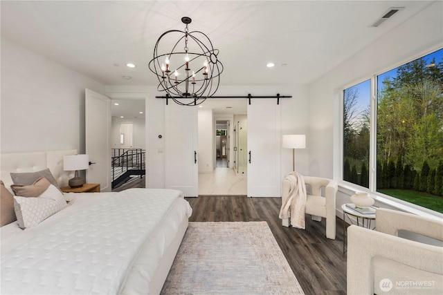 bedroom with a notable chandelier, recessed lighting, dark wood-style floors, a barn door, and visible vents