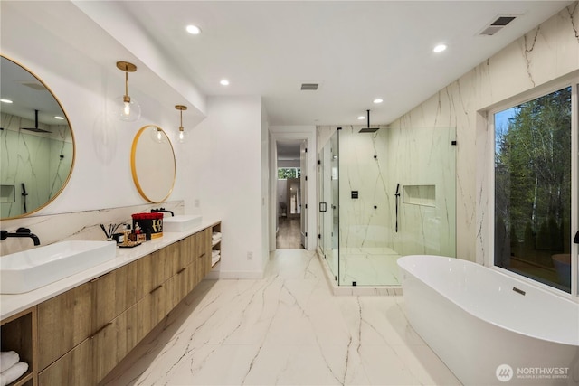 full bath featuring a sink, visible vents, a marble finish shower, and recessed lighting