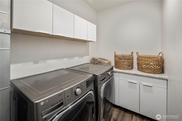 laundry room featuring cabinet space, washer and dryer, and dark wood-type flooring