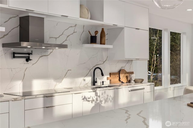 kitchen featuring open shelves, a sink, wall chimney exhaust hood, and modern cabinets