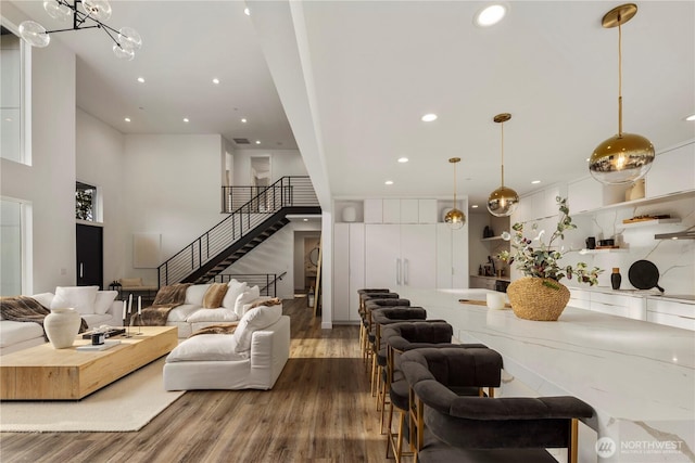 living area featuring wood finished floors, recessed lighting, and stairs