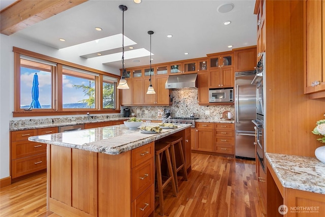 3193 Northshore Rd, Bellingham, WA 98226 - kitchen featuring built in appliances, brown cabinets, under cabinet range hood, and light wood-type flooring