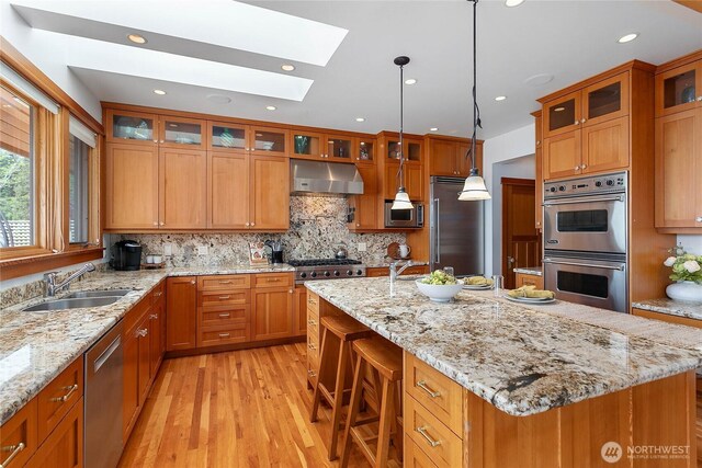 3193 Northshore Rd, Bellingham, WA 98226 - kitchen featuring brown cabinetry, appliances with stainless steel finishes, a sink, under cabinet range hood, and light wood-style flooring