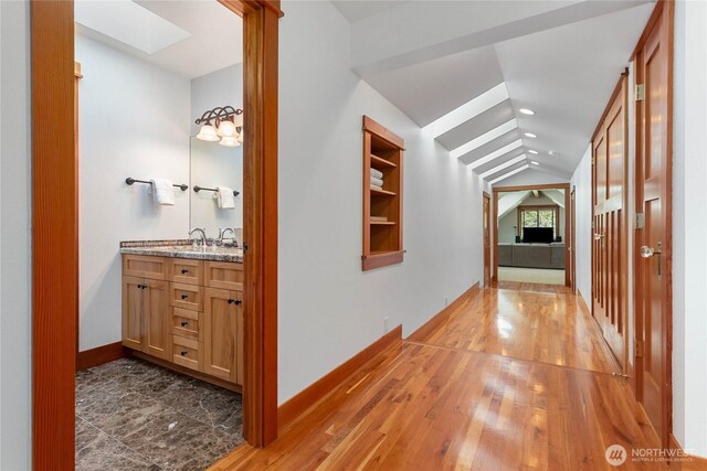 3193 Northshore Rd, Bellingham, WA 98226 - hallway with recessed lighting, baseboards, wood finished floors, and vaulted ceiling with skylight