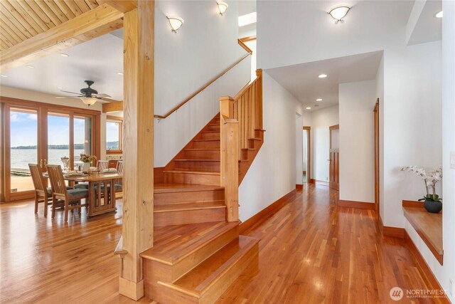 3193 Northshore Rd, Bellingham, WA 98226 - stairway featuring ceiling fan, wood finished floors, baseboards, a water view, and recessed lighting