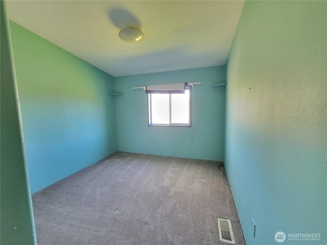 unfurnished room with carpet floors and visible vents