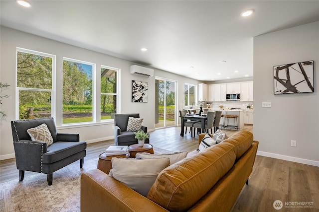 3009 Oleander Ln, Blaine, WA 98230 - living room featuring baseboards, a wall mounted AC, and light wood finished floors