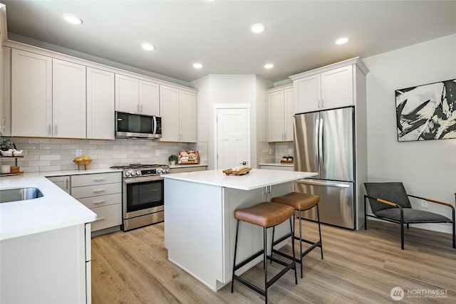 3009 Oleander Ln, Blaine, WA 98230 - kitchen featuring a kitchen bar, a center island, light countertops, light wood-style floors, and stainless steel appliances