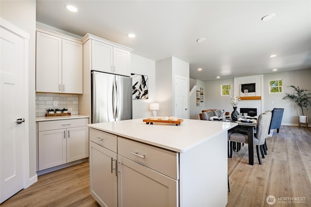 3009 Oleander Ln, Blaine, WA 98230 - kitchen with backsplash, a center island, light countertops, freestanding refrigerator, and light wood finished floors