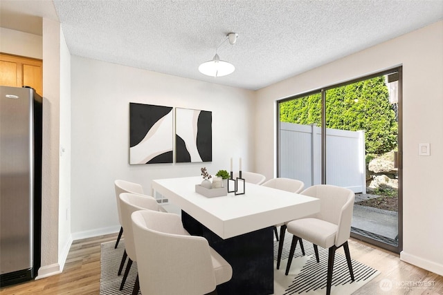 1555 Union Ave NE Unit 27, Renton, WA 98059 - dining space with light wood-style flooring, baseboards, and a textured ceiling