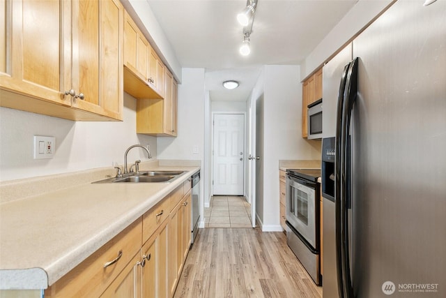 1555 Union Ave NE Unit 27, Renton, WA 98059 - kitchen with appliances with stainless steel finishes, a sink, light brown cabinetry, light countertops, and light wood-type flooring