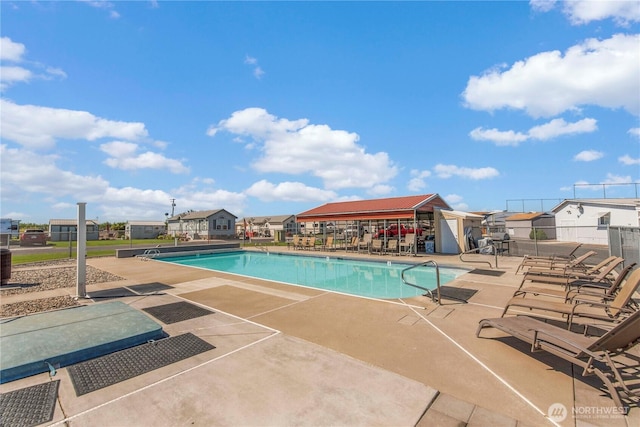 pool with a patio and fence