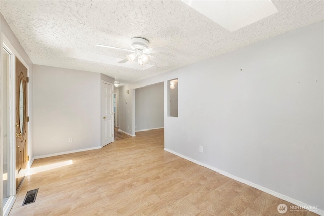 2607 SE 138th Loop, Vancouver, WA 98683 - empty room featuring a textured ceiling, light wood-style flooring, a ceiling fan, and a skylight