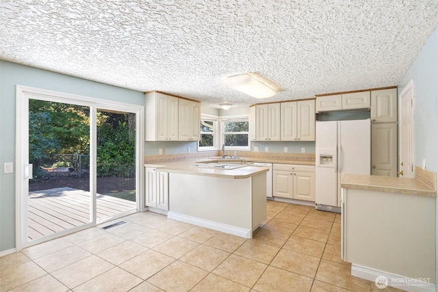 2607 SE 138th Loop, Vancouver, WA 98683 - kitchen with white appliances, a peninsula, light tile patterned flooring, light countertops, and a textured ceiling