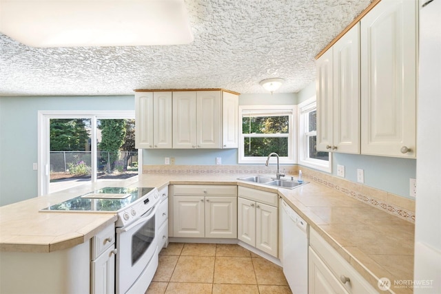 2607 SE 138th Loop, Vancouver, WA 98683 - kitchen with white appliances, a peninsula, light tile patterned flooring, white cabinets, and a textured ceiling